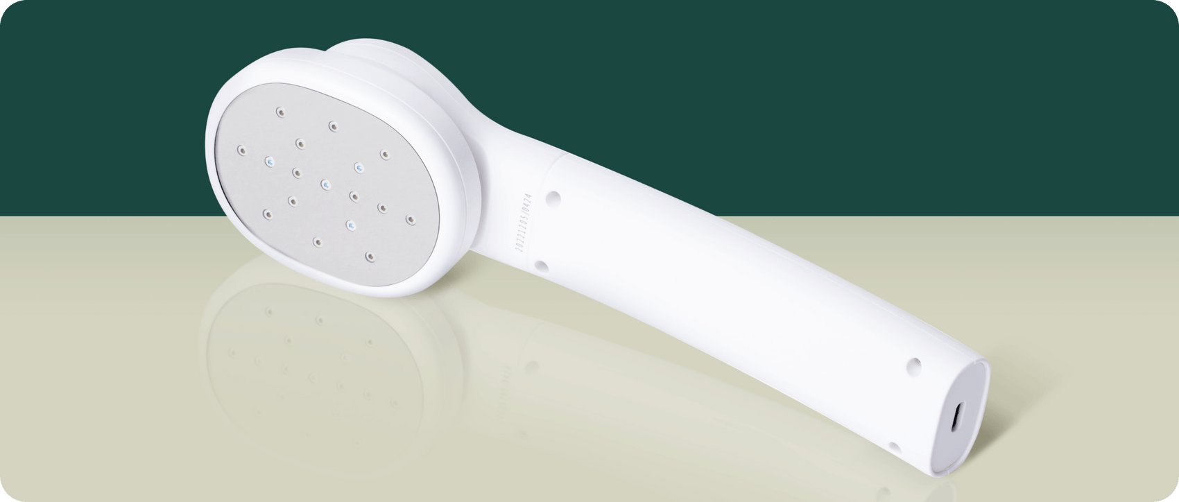White handheld shower head with multiple small spray nozzles on a reflective surface